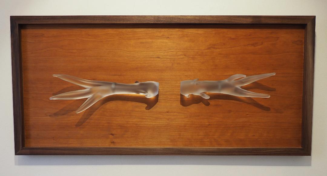 A pair of frosted glass antlers mounted as wall pieces